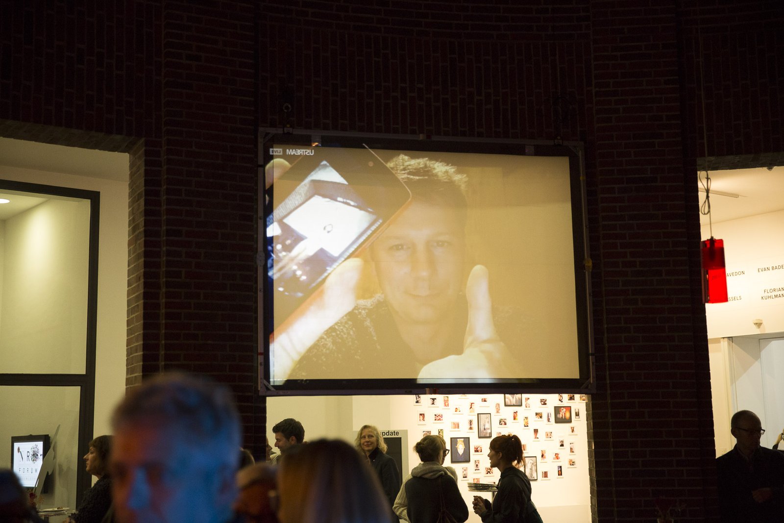The streamed face giving a thumbs-up, phone in hand, on the screen at the opening