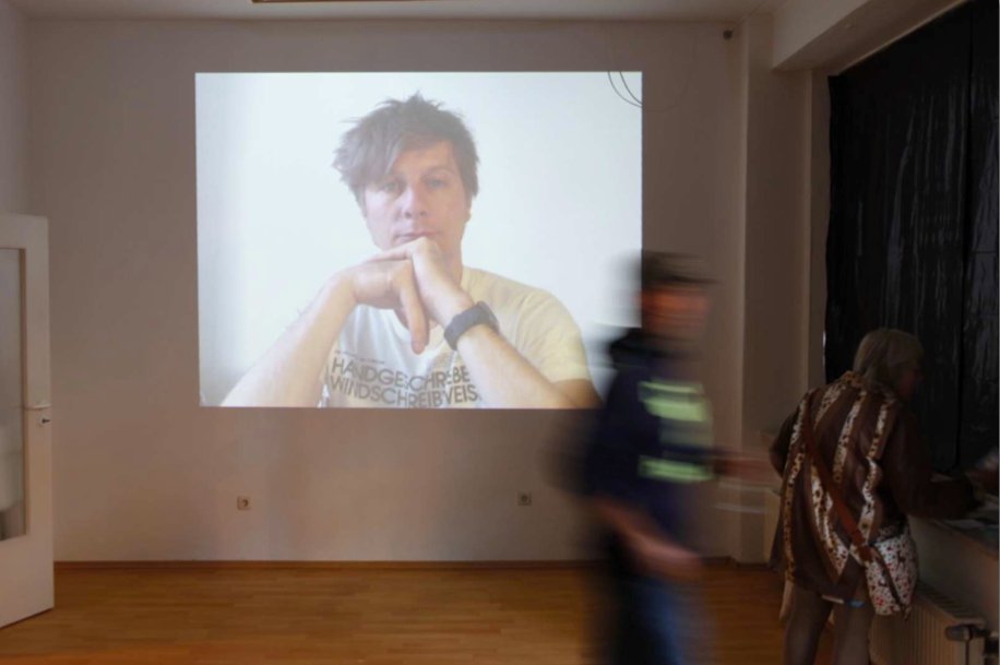 Hannover 2011 — the projected face on a wall, a passer-by blurred in motion